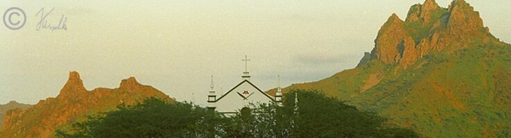 Kapelle mit Blick auf Felsmassiv