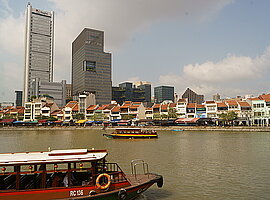 Blick von der Esplanade on the Bay auf Raffles Place über den Singapore River mit Fährbooten